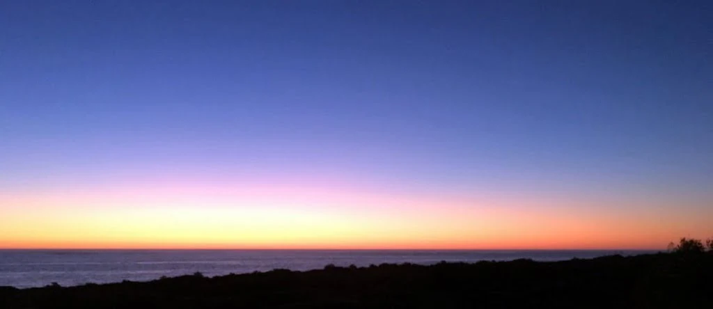 Stunning sunset over the ocean near Perth, Western Australia, with a gradient sky shifting from deep blue to soft orange and pink. A peaceful coastal view perfect for Retirement Wanderlust, inspiring a serene, travel-focused retirement lifestyle.